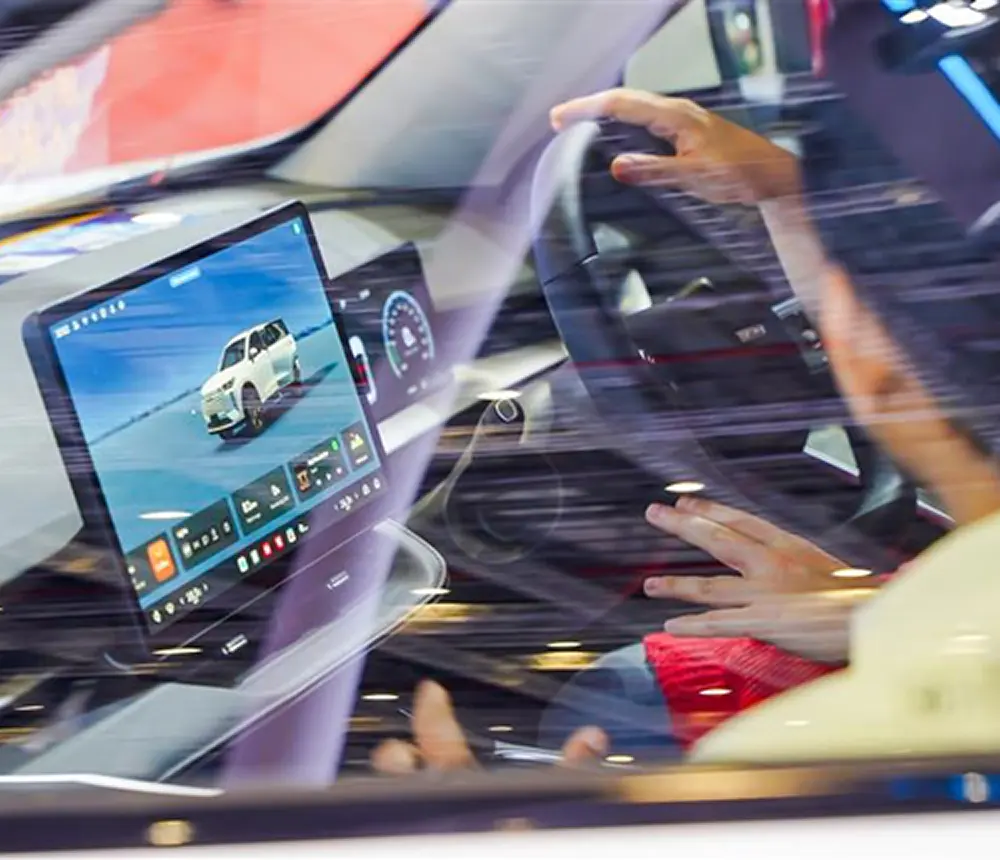 Close up of driver and passenger in car cockpit with a view of the central electronic HUD.
