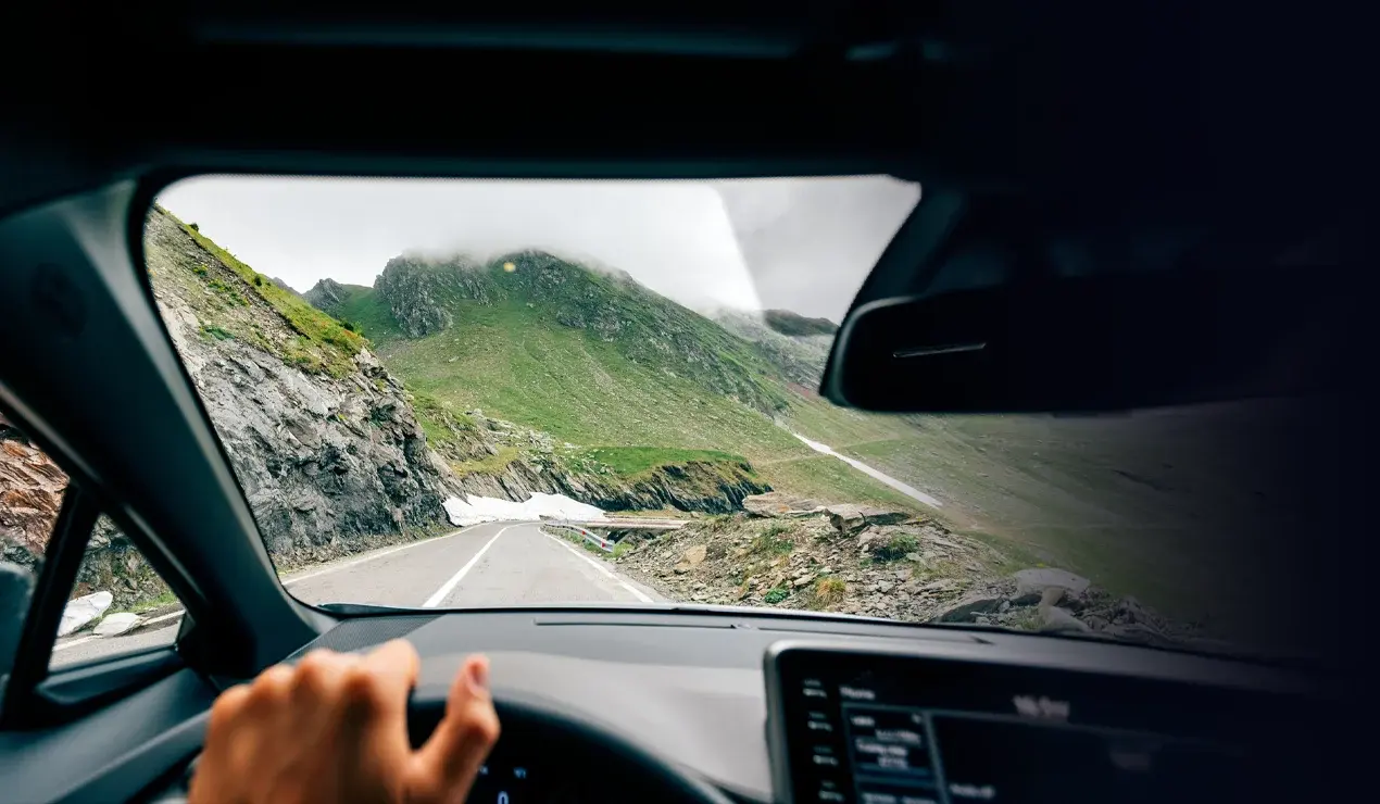 looking out the front of a car driving in the mountains
