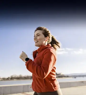 Woman running with smart watch and ear buds